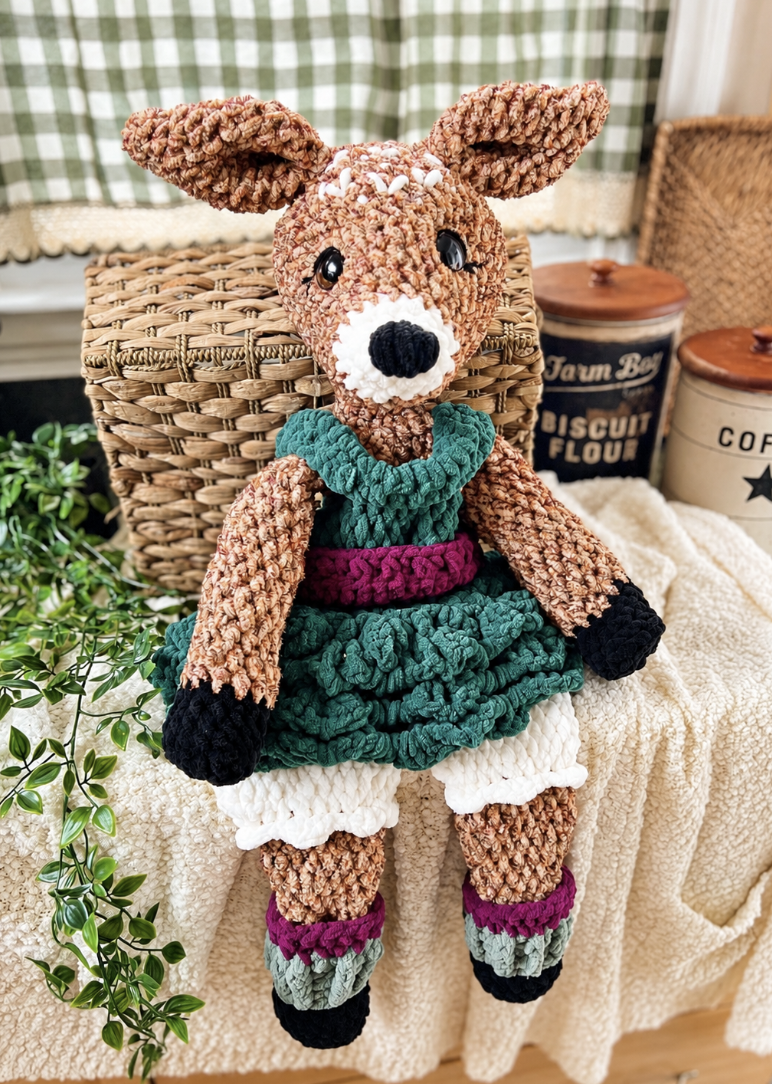 A crocheted mushroom elf with a red spotted cap, pointed ears and green shorts